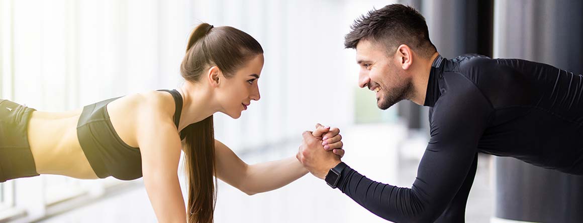 fitness uomo e donna si aiutano in posizione plank